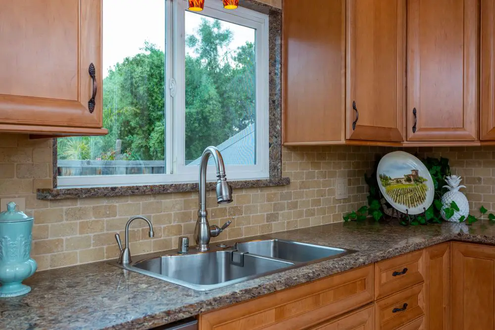 “East Bay kitchen with high-arc single-handle faucet and pull-down sprayer, easy to use for arthritic hands, set against natural wood cabinetry.”