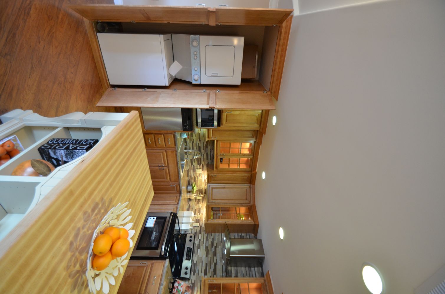 Stacked washer and dryer concealed inside a floor-to-ceiling kitchen cabinet next to the cooking area, illustrating a space-saving Rossmoor laundry nook design that integrates in-unit laundry into an older East Bay kitchen without sacrificing style or function.