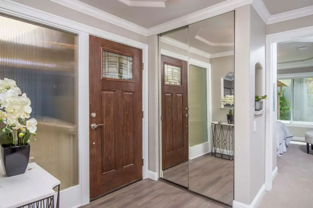 Entryway remodel with wood front door and mirrored closet doors in Walnut Creek
