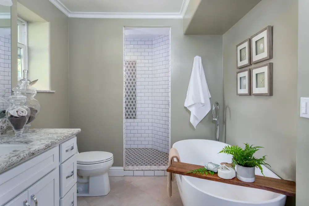 Fresh East Bay bathroom remodel with a freestanding tub, walk-in shower with white subway tile, and soft sage walls for a spa-like feel — by Toupin Construction.