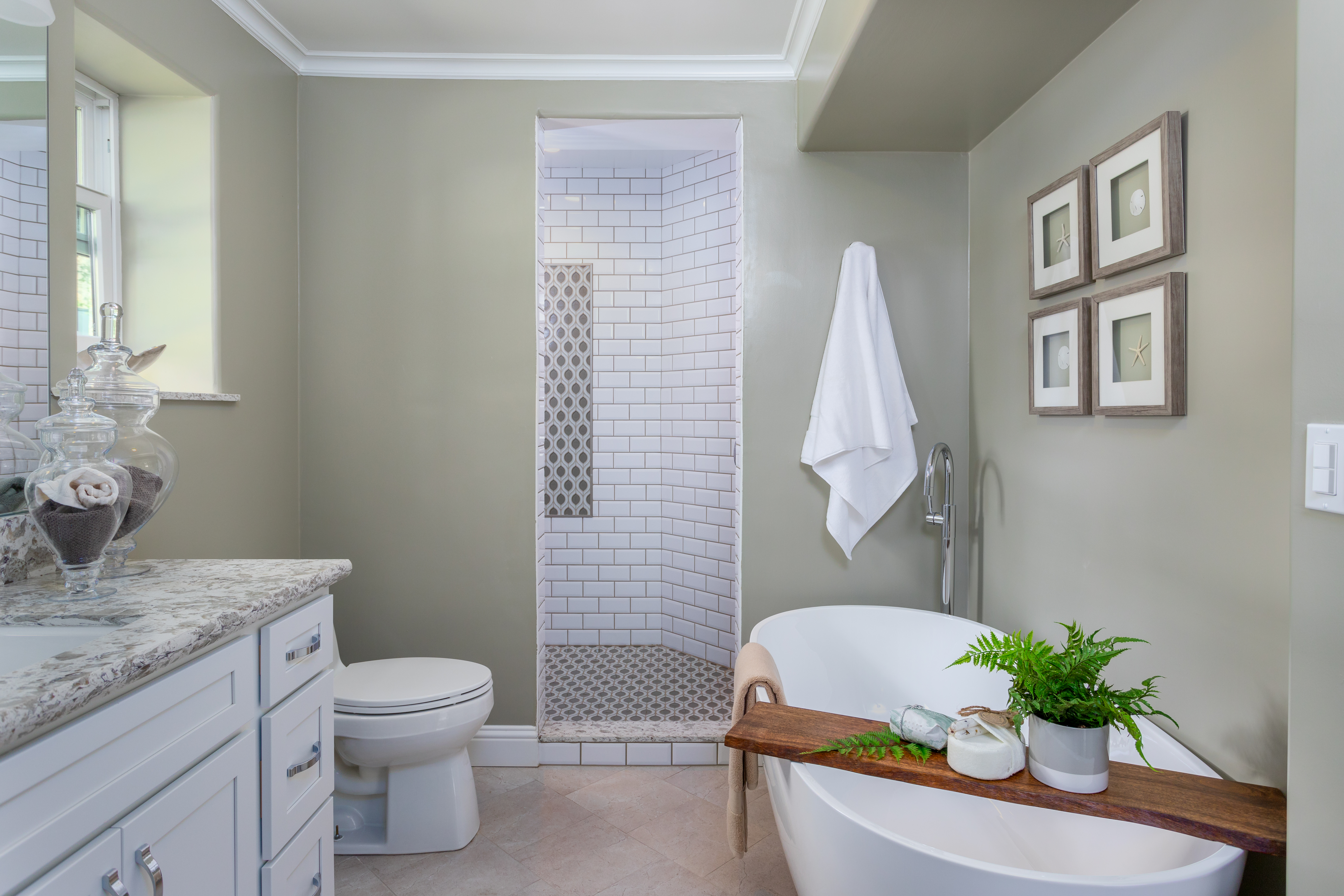 sea moss green bathroom with white subway tiles and soaking tub 