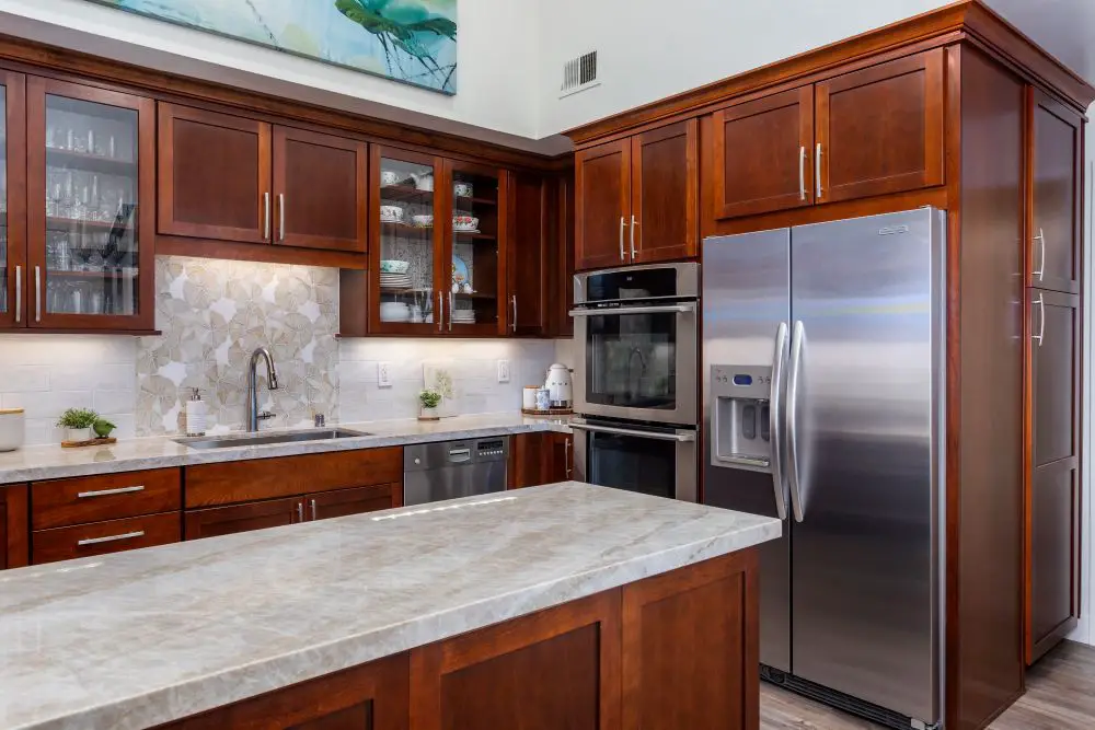 Elegant kitchen remodel featuring rich cherry cabinets, quartz countertops, stainless steel appliances, and a patterned tile backsplash. Designed and built by Toupin Construction in the East Bay.