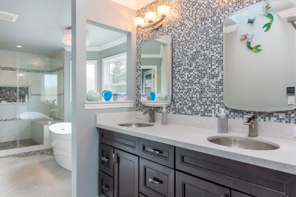 Bathroom with blue mosaic tile backsplash and dark wood vanity with double sinks