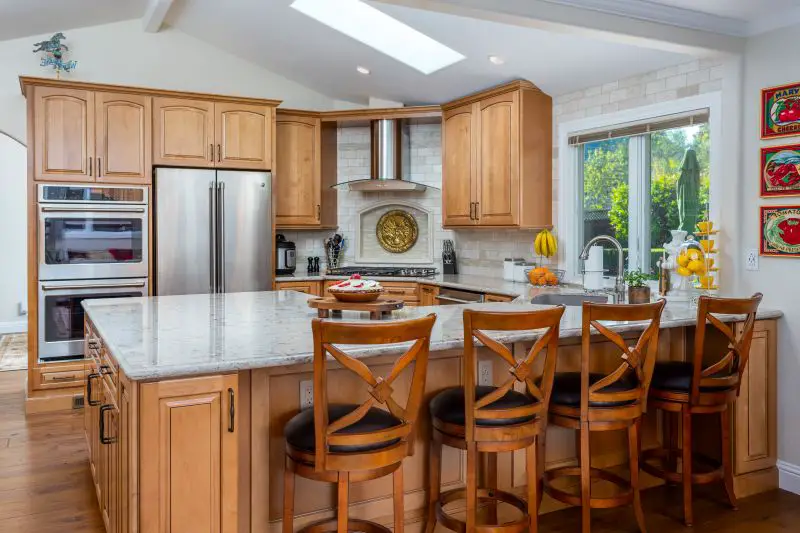 Orinda kitchen remodel with warm wood cabinetry, large quartz island, stainless steel appliances, and skylight for natural light