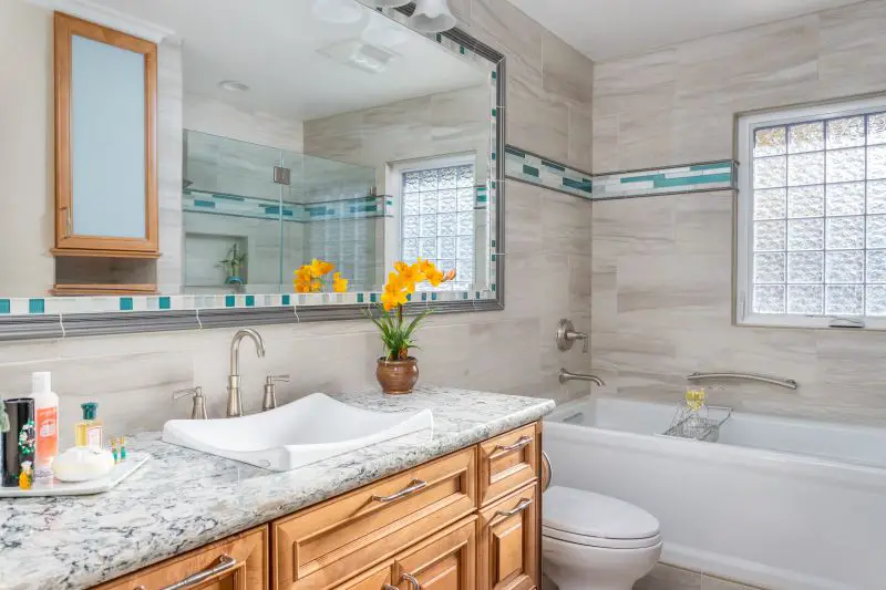 Orinda bathroom remodel with wood vanity, granite countertop, vessel sink, soaking tub, and aqua glass tile accent strip
