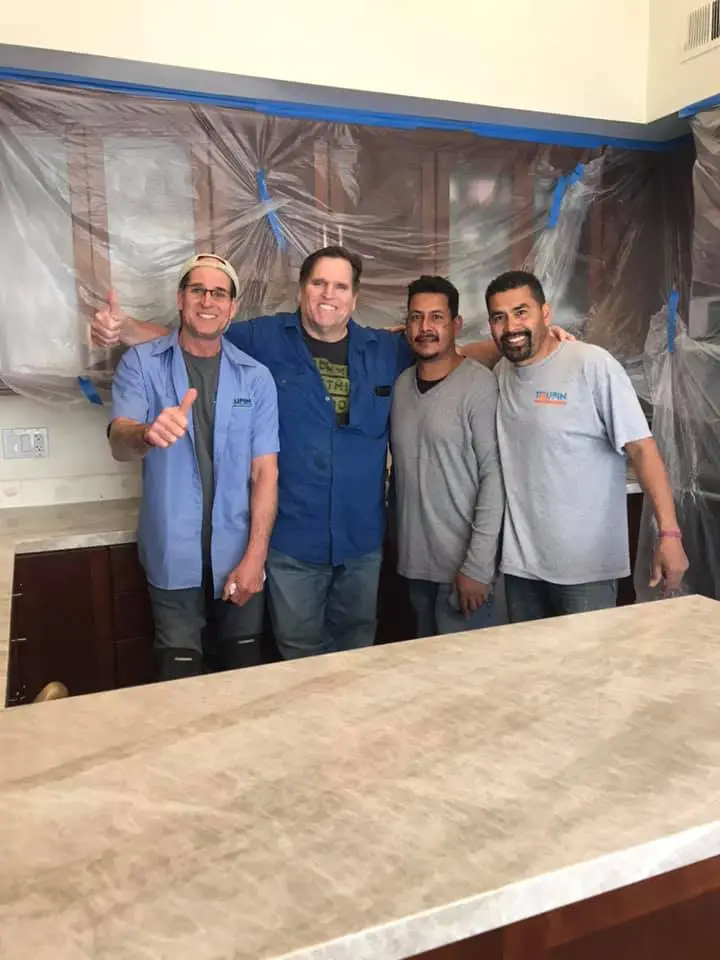 Tim Toupin posing with members of the Toupin Construction team inside a remodeling project.