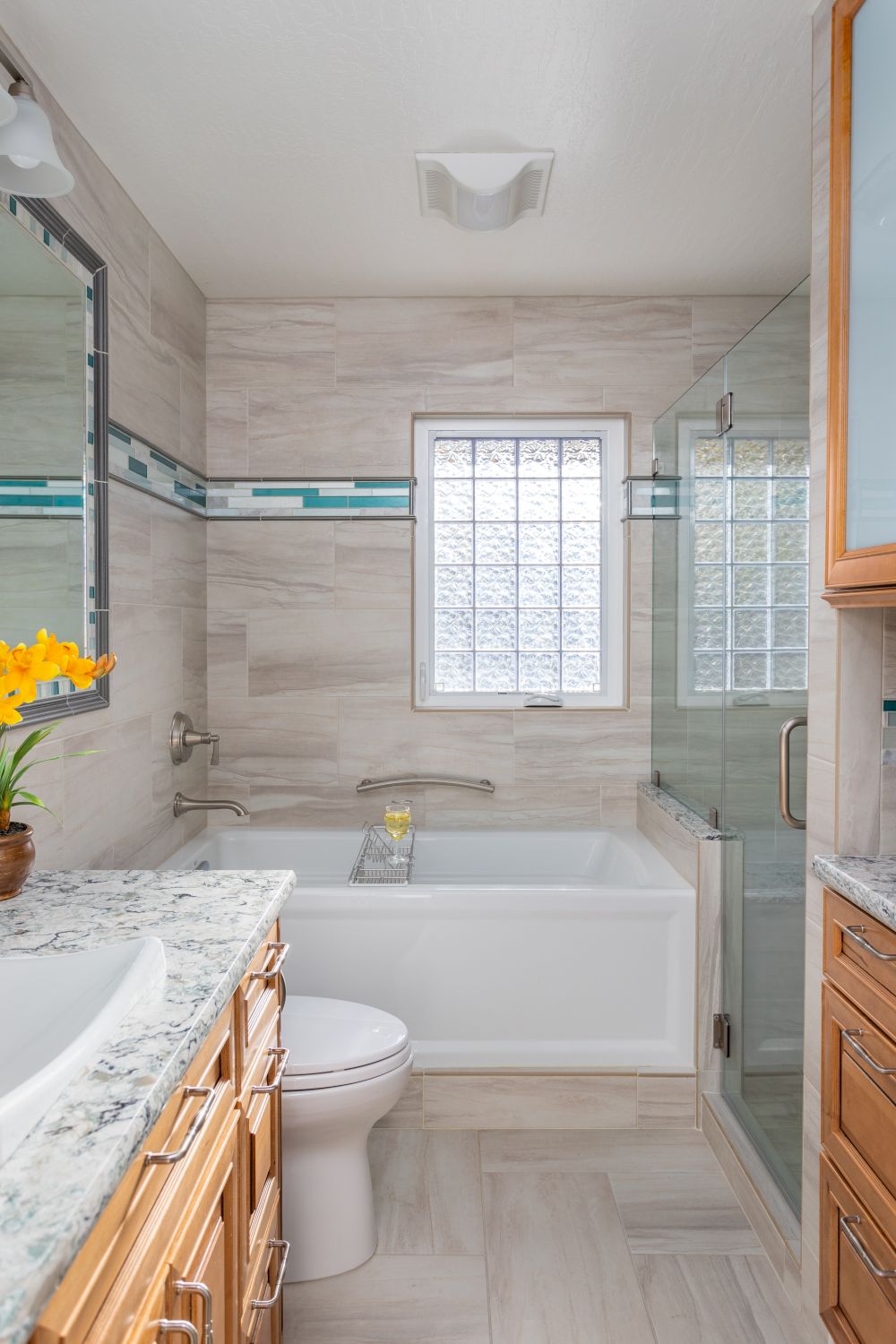 Bathroom with tub shower combo, glass block window, and neutral tile surround