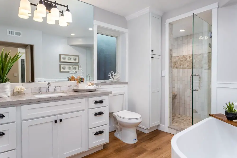 Bathroom with white vanity, quartz countertop, and glass shower enclosure
