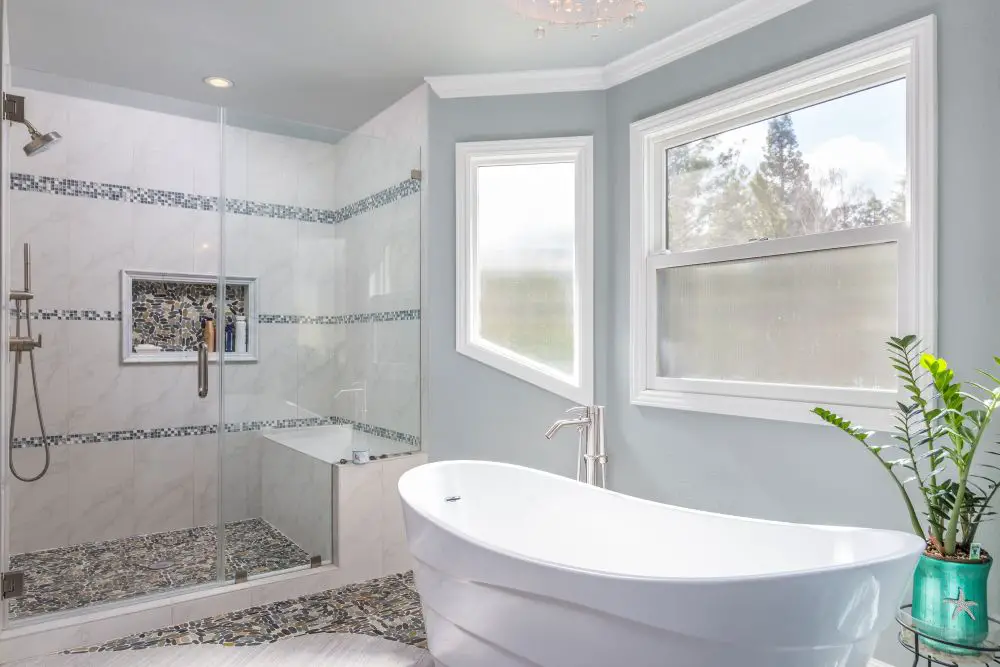 Classic bathroom with freestanding tub and walk-in glass shower filled with natural light