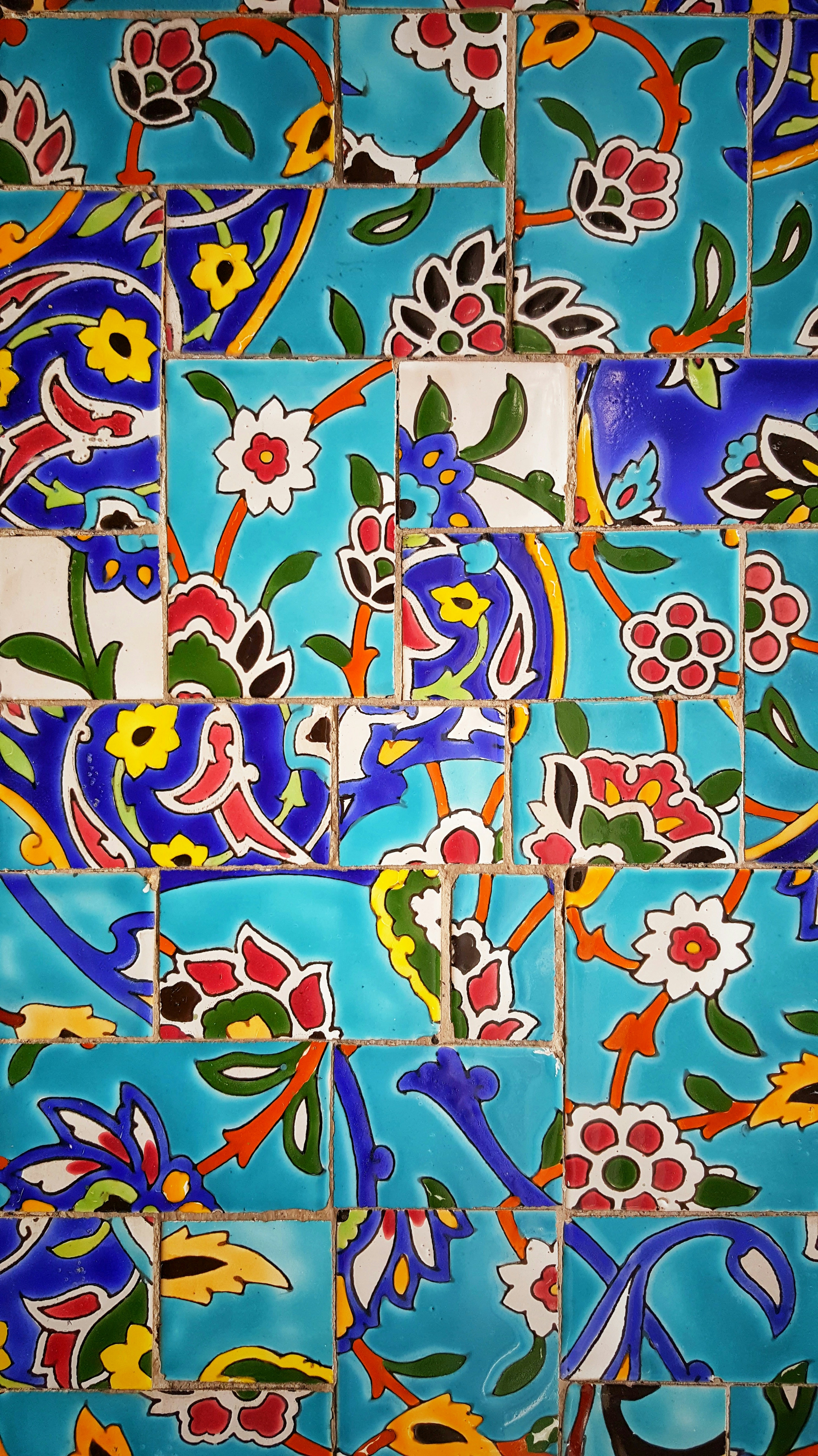 Spanish-inspired patterned ceramic tile wall with colorful geometric and floral designs.