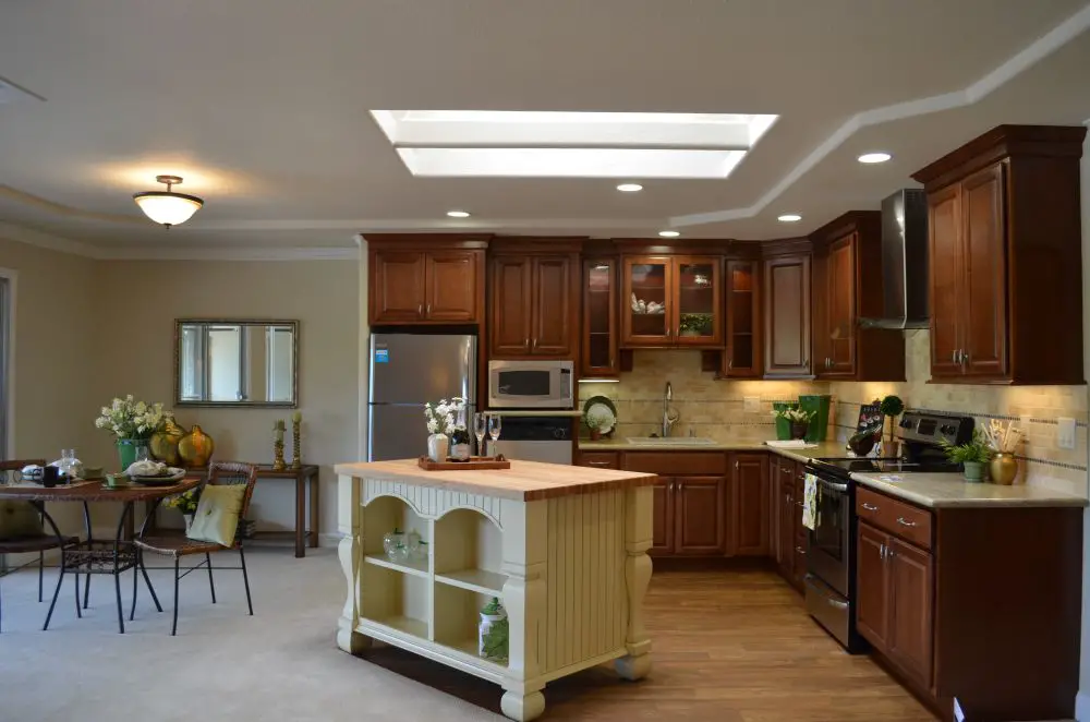 Kitchen remodel with wood cabinets, center island, skylight, and open-concept dining area