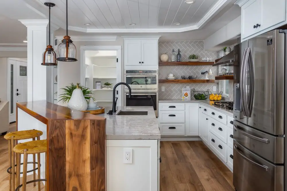Lafayette kitchen with warm white paint cabinets, wood island accent, open shelving, and neutral finishes
