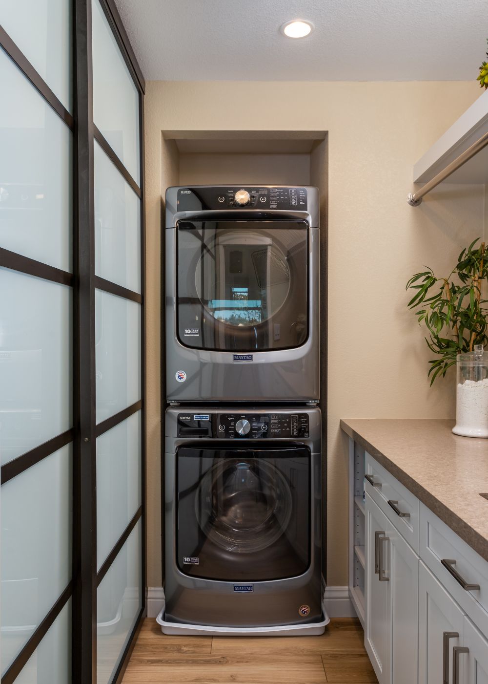 Stacked washer and dryer in small laundry closet Moraga CA space-saving laundry design with recessed niche