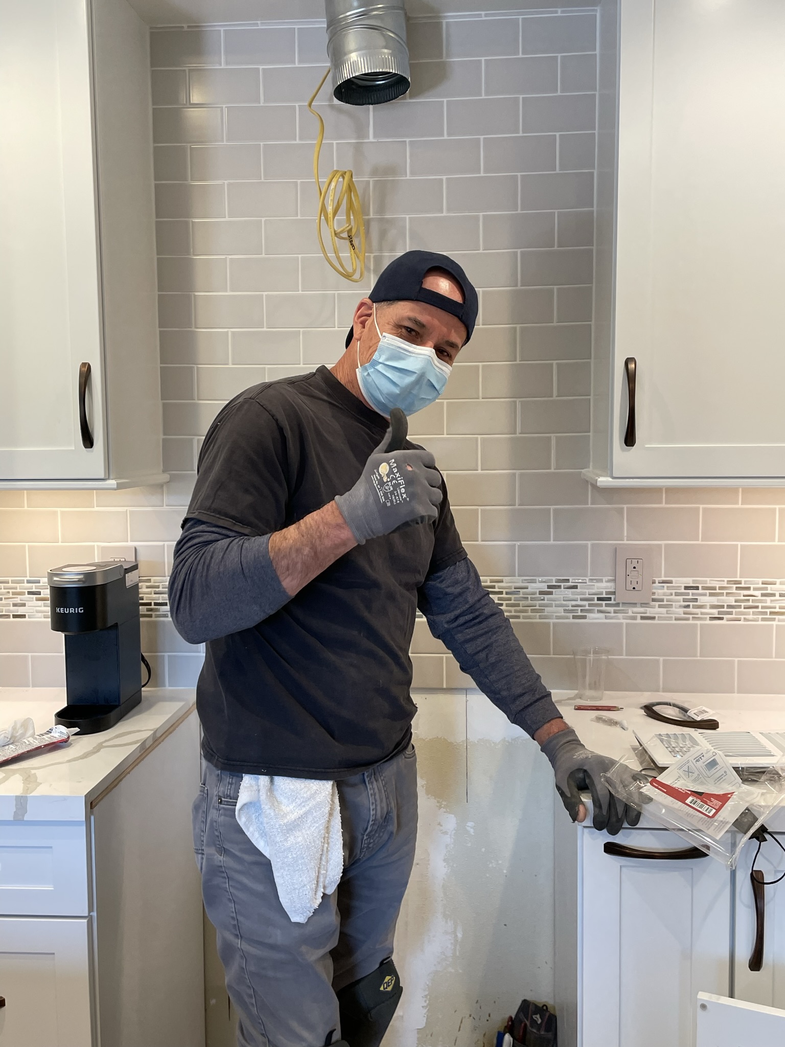 Licensed electrician from Toupin Construction wiring new kitchen outlets during a remodel, ensuring GFCI and Title 24 compliance.