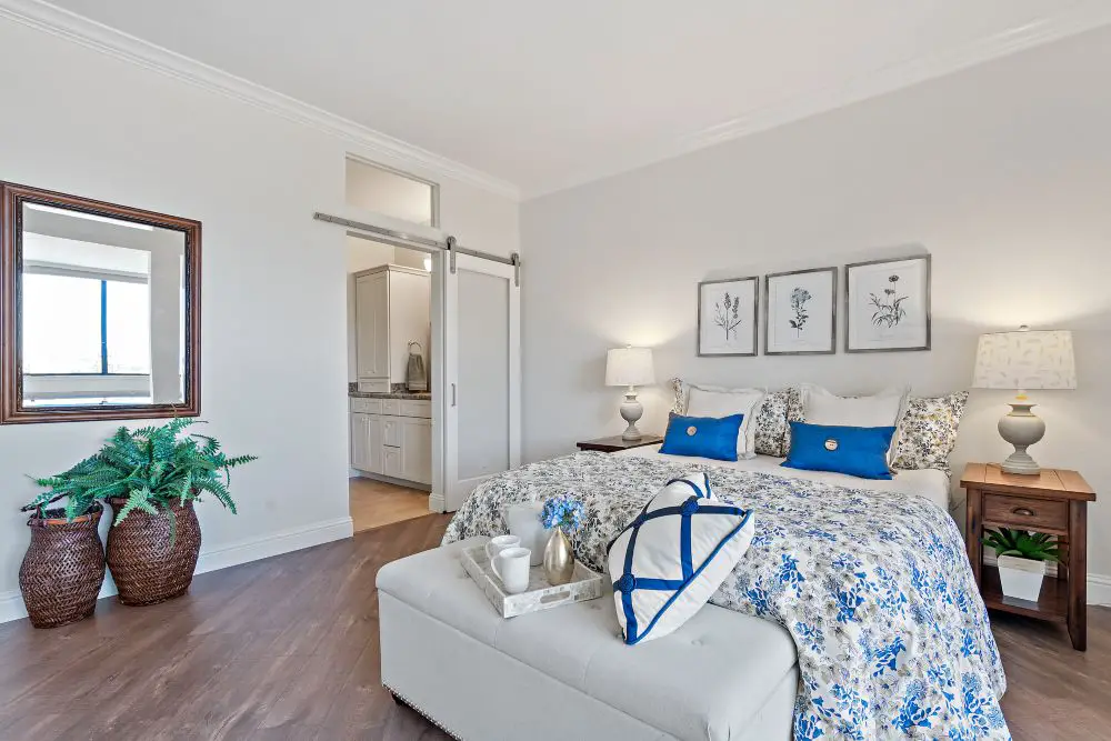 Primary bedroom with sliding door leading to ensuite bathroom and neutral modern decor