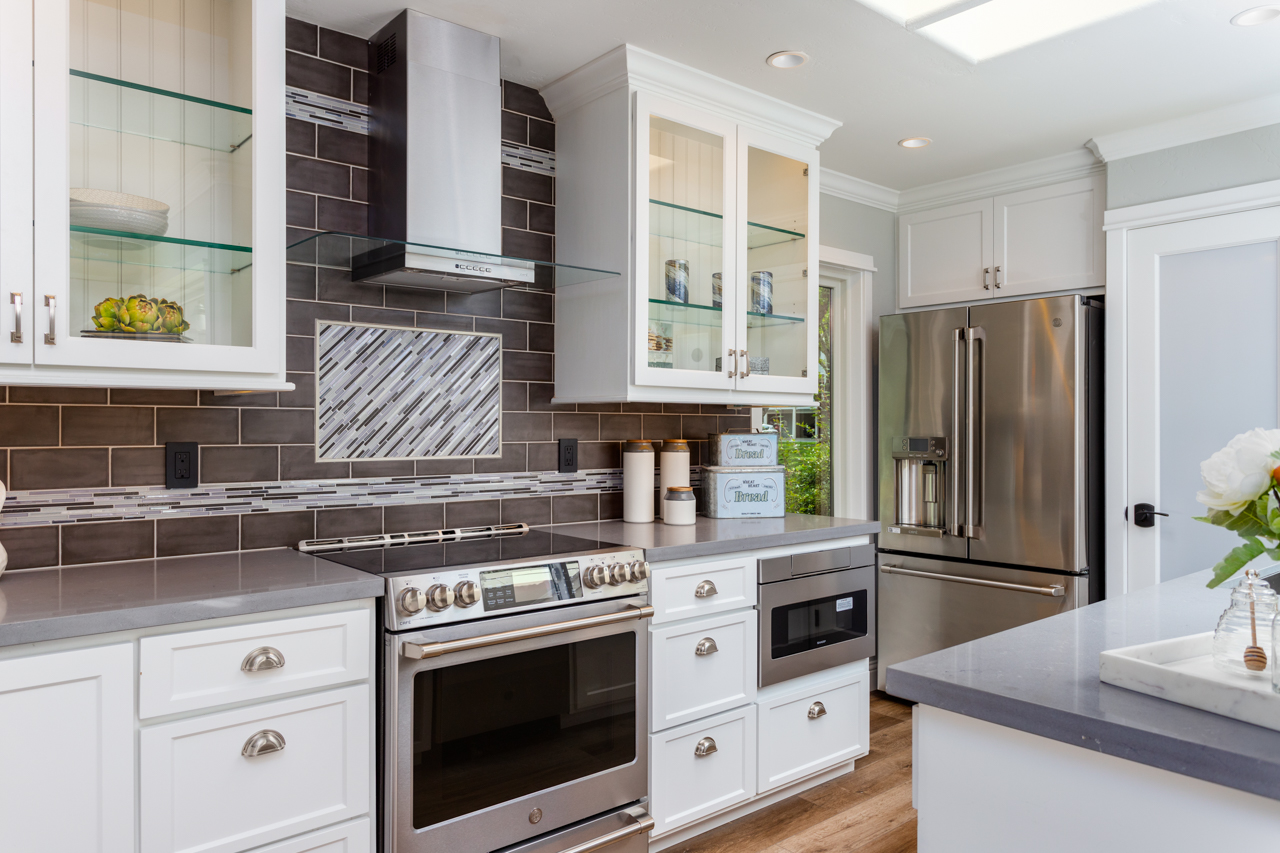 Subway tile backsplash with decorative accent insert behind range in Rossmoor kitchen