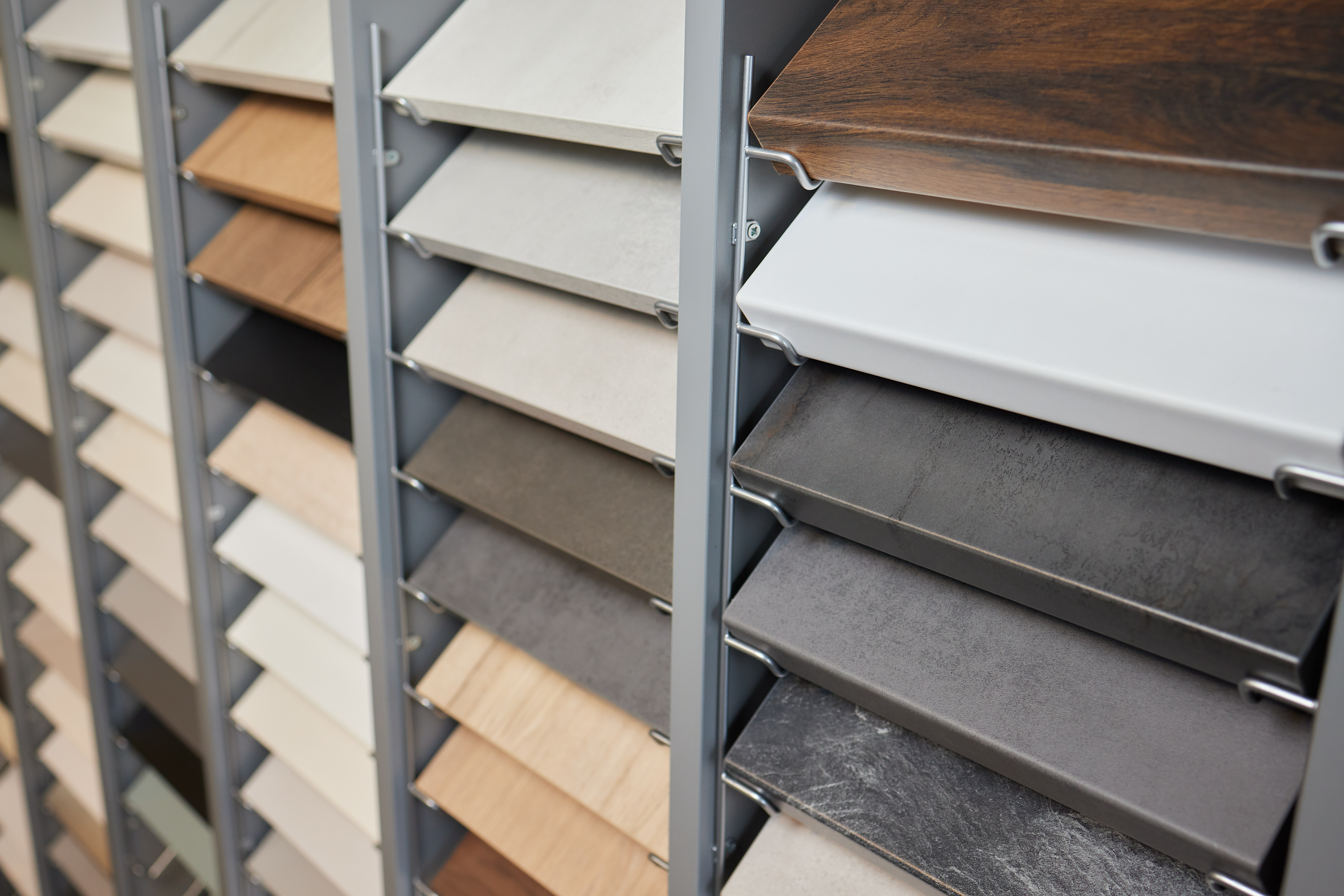 Kitchen and bathroom material sample display with cabinet finishes and countertop selections in remodeling showroom.