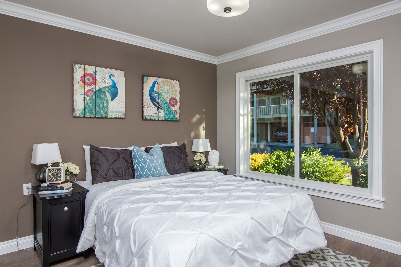 Bedroom with taupe accent wall and large window in Walnut Creek home