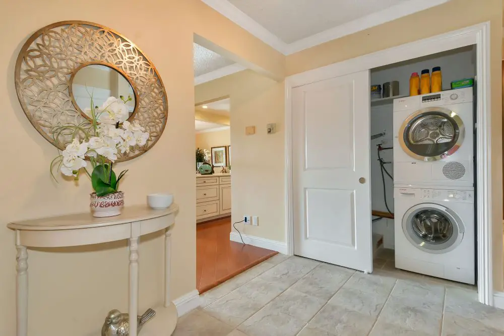 Stacked washer and dryer in hidden laundry closet Walnut Creek CA behind sliding doors compact laundry space design