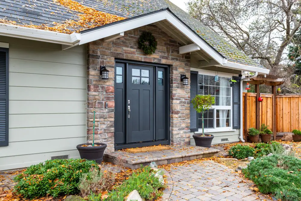 Front entry with black double doors, stone veneer, and landscaped walkway in Walnut Creek