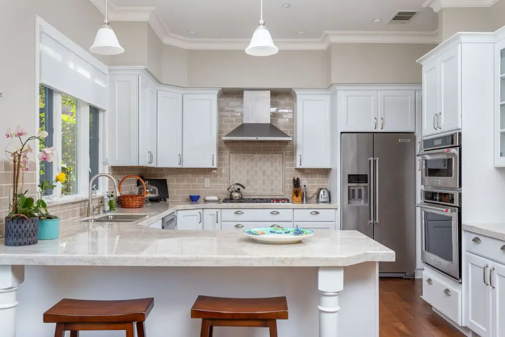 Kitchen with island and pendant lighting in an open layout with white cabinets
