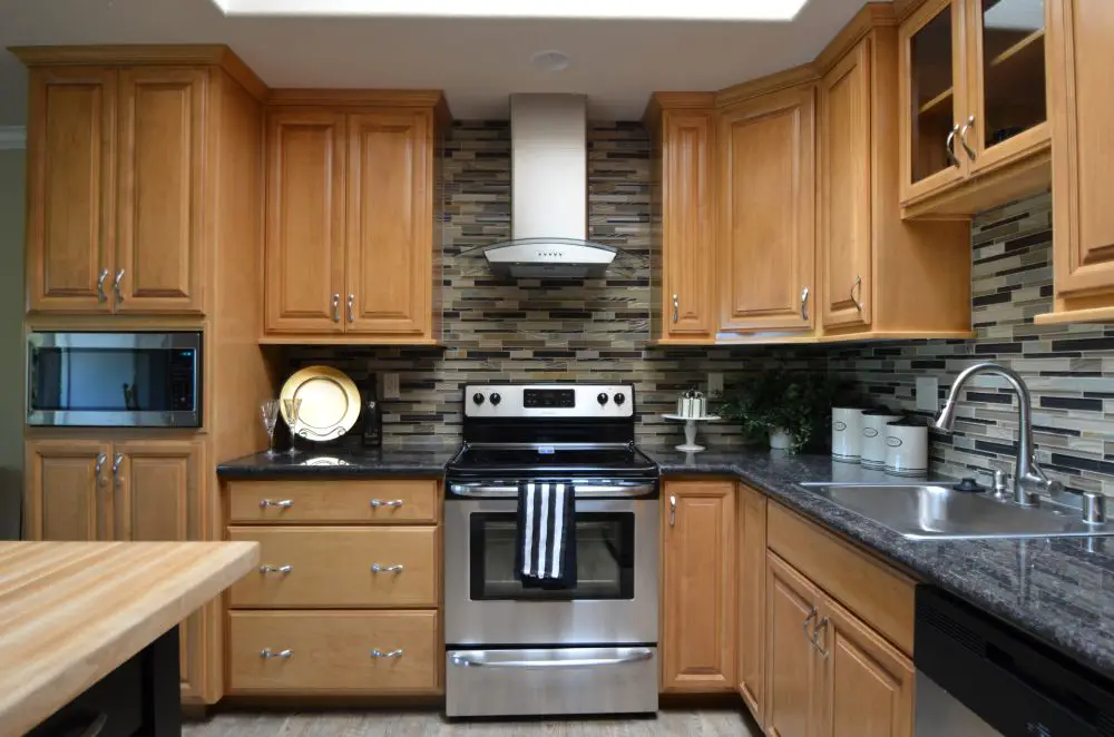 Kitchen with light wood cabinets, island seating, and skylights for natural light