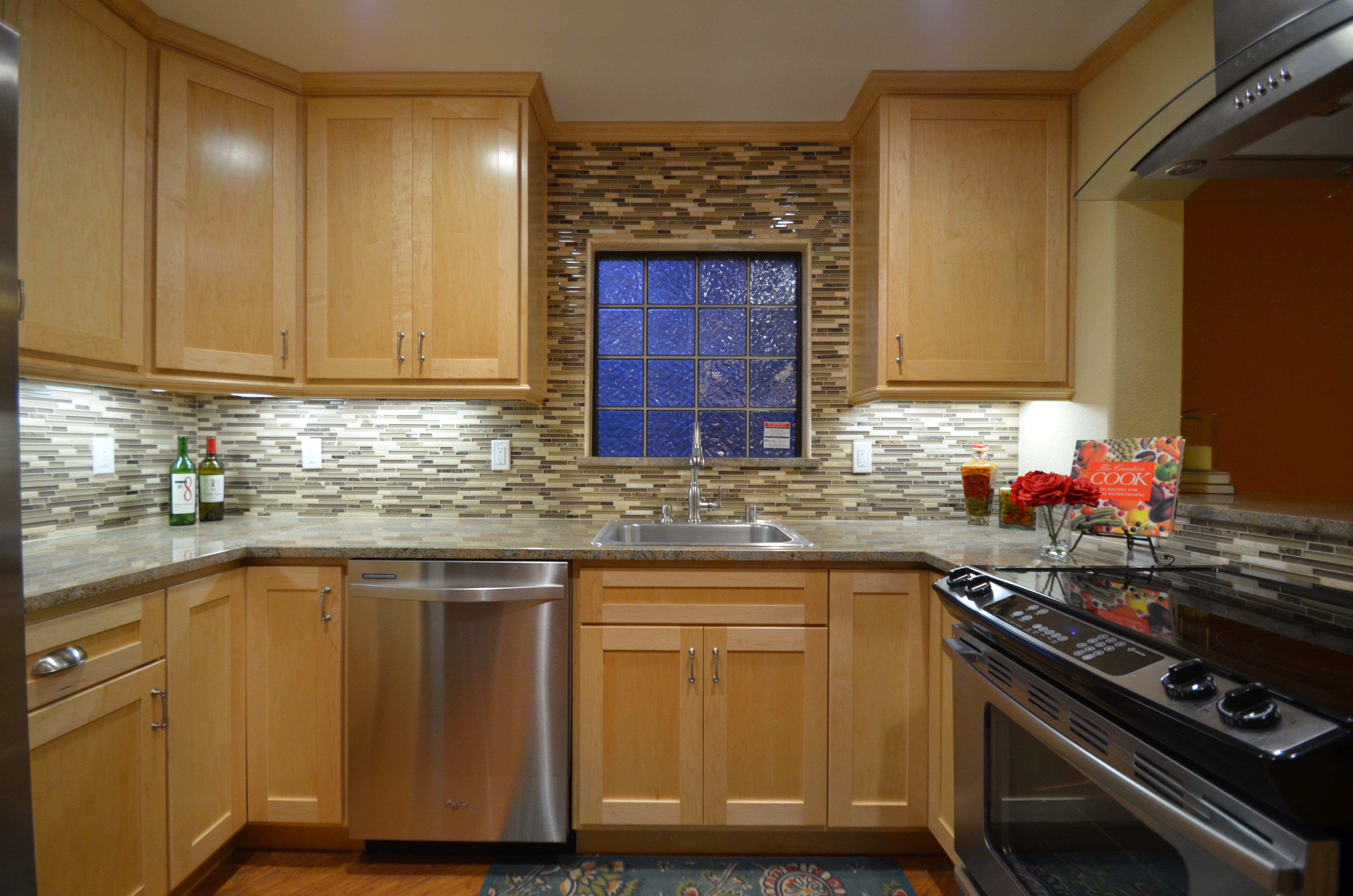 Kitchen with window, mosaic backsplash, and under cabinet lighting