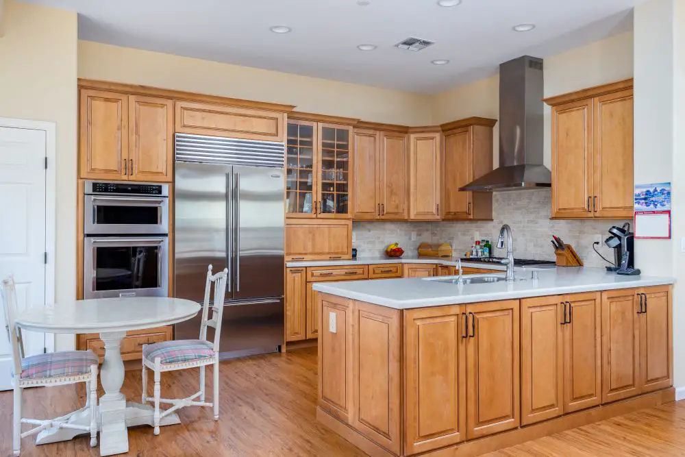 Light wood kitchen cabinets with white countertops and stainless steel appliances in Walnut Creek remodel