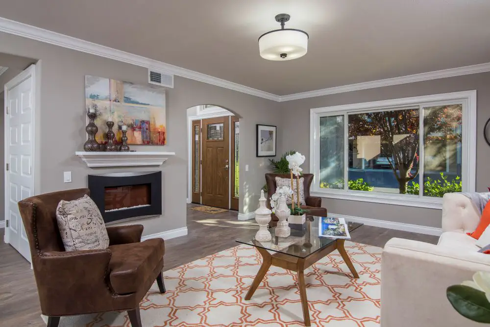 Living room with modern fireplace, large picture window, and natural light in Rossmoor Walnut Creek condo