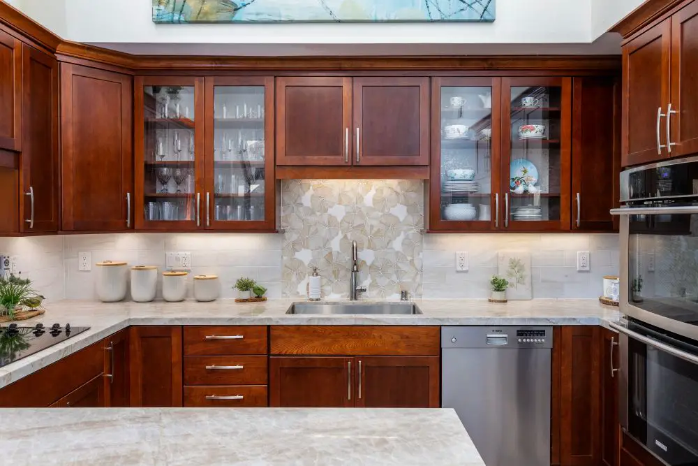 Kitchen with white cabinets and full-height granite backsplash matching countertops.