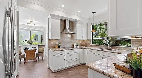 Open-concept kitchen remodel featuring white shaker cabinetry, granite countertops, stainless steel appliances, luxury vinyl plank flooring, and an adjacent breakfast nook. Rossmoor Kitchen & Bathroom Remodel | Terra Granada Walnut Creek