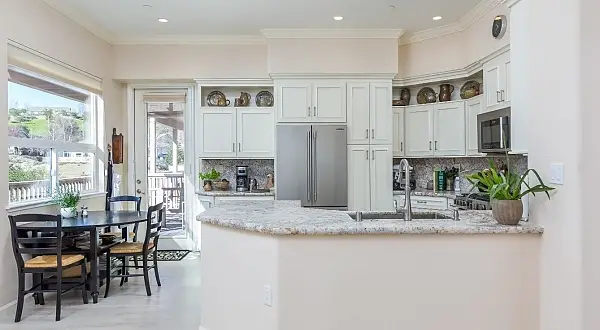 This client had a wonderful pottery collection she loved and wanted to display, so the design of the kitchen incorporated some wonderful open shelves for her to utilize for that purpose.   The original peninsula bar top blocked and closed off the room, lowered to all one level now it’s a much more open look.  Other reorganization of the space allow for better functionality and storage options.  No corners are wasted.  The master bathroom got a beautiful remodel to update it.  While the tub and tub filler was kept, a new elegant tile wainscoting wraps the tub area and new vanity backsplash area.  Very subtle soft creams and neutral tones give a soothing feel to the space.