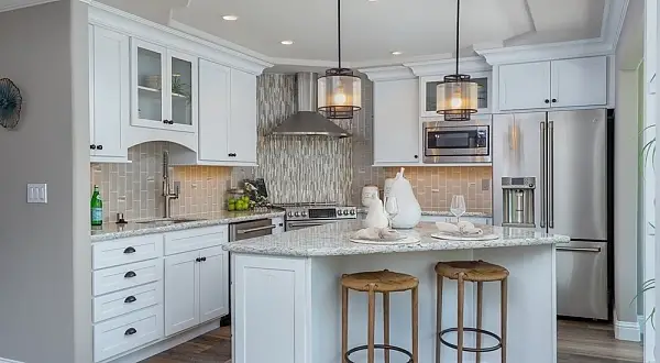 This Sonoma wrap got a complete overhaul, including the addition of a full second bathroom space, expansion of the master bath and relocation of the kitchen. Bright and airy white cabinetry and warm gray-brown tones were used throughout this unit aligned with current color trends. Quartz countertops, ceramic tiled showers and backsplash areas with glass tile accents, and LVT luxury Vinyl Plank flooring are featured. The enclosed veranda was opened up more to the kitchen and living room spaces with glass shelves between the existing two supporting posts.