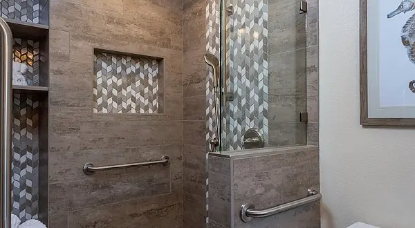 Accessible walk-in shower in a Concord bathroom remodel featuring large-format porcelain tile, decorative accent tile, built-in shower niche, frameless glass, and grab bars. Concord Kitchen & Bathroom Remodel | Custom Cabinets & Accessible Shower