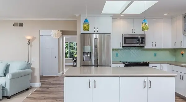 White kitchen with peninsula, skylight, and stainless steel appliances in a Golden Rain remodel in Rossmoor. Golden Rain Kitchen & Bathroom Remodel | Rossmoor, Walnut Creek
