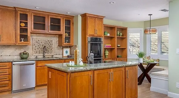 Custom kitchen remodel in Rossmoor featuring warm maple cabinetry, granite countertops, large island, and built-in breakfast nook in Walnut Creek. Rossmoor Terra Granada Condo Remodel | Walnut Creek