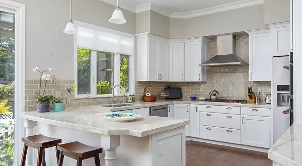 This kitchen was reconfigured in order to make a more functional work triangle, and also to open up and enhance the space. Subtle creams and whites make for a soothing, restful pallet, grounded by the rich hardwood floors. The fireplace area was modernized to allow for a linear fireplace and wall mounted TV, with the extra drama of floor to ceiling stone work. A cement cast mantle allows for heat deflection. In the master bathroom Green Accents in the tile work and quartz countertops bring a little drama to the otherwise subtle creamy tones. We built the desk and storage cabinetry on site for the client to create the perfect office space customized to her specific needs.