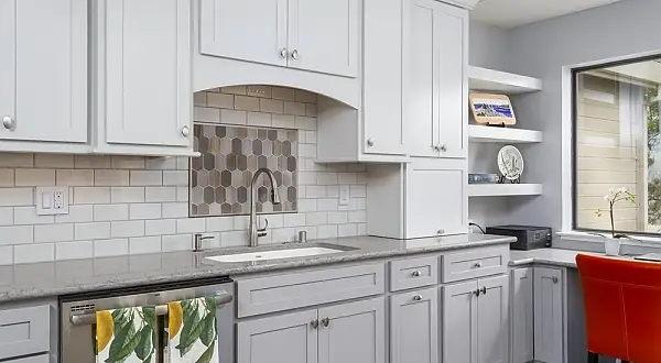 Light gray kitchen cabinets with quartz countertops and a decorative mosaic backsplash in a Terra Granada home in Rossmoor. Terra Granada Kitchen & Bath Remodel | Rossmoor